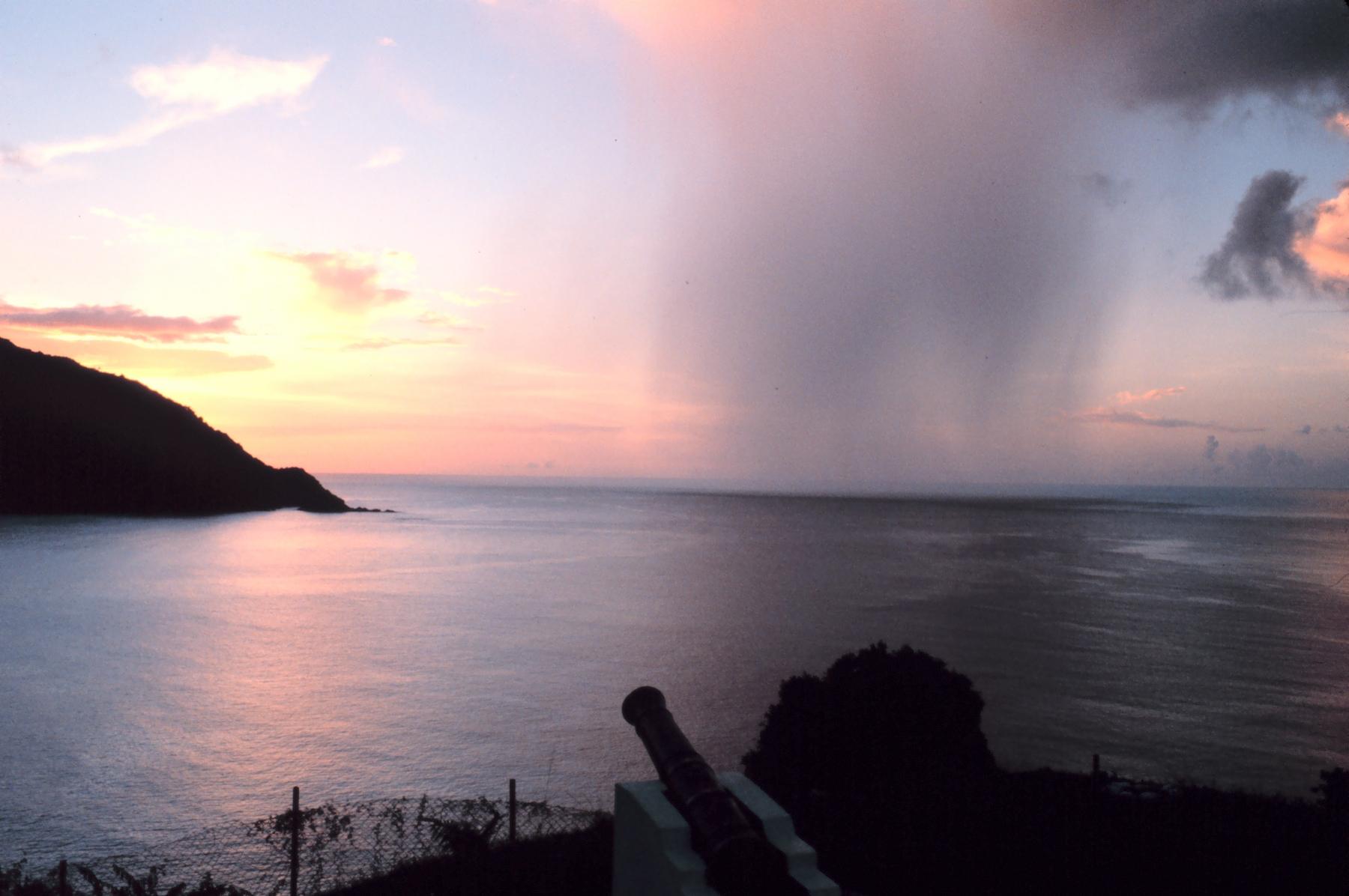 A rain shaft crossing the open sea at sunset off Man-of-War Bay